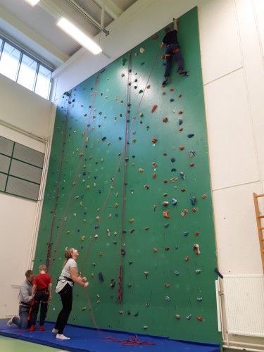 Ungdomar klättrar uppför klötterväggen in i Kronoby idrottshall.