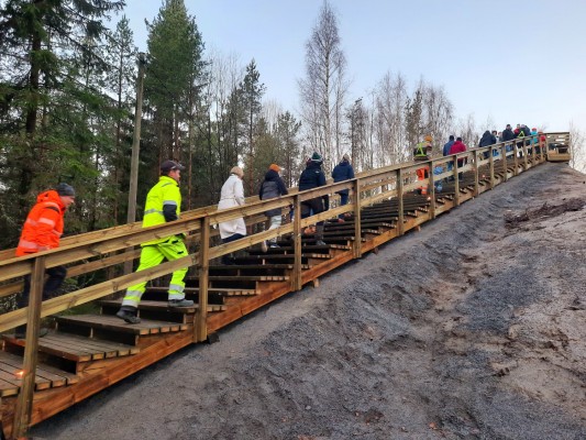 en motionstrappa byggd av ved på en backe mitt i skogen