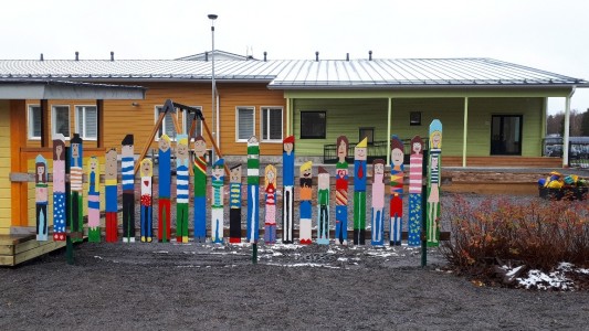 Kuva: Taideaita Alavetelin esikoulun pihalla, jossa aitaan on maalattu erilaisia ihmisiä.